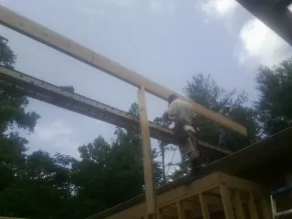 Carpenter setting a ridge beam over a new addition frame — Ice Dam Removal by Roofing Brothers in Yamhill