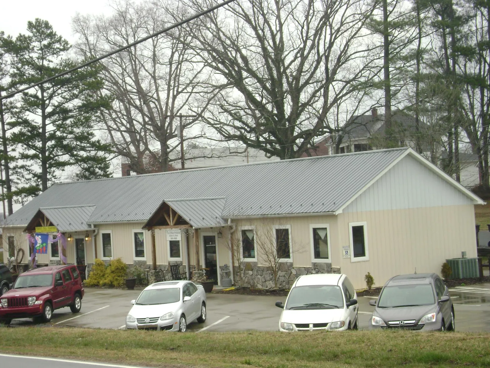 Gray metal roof with timber entry brackets on a small commercial building in Yamhill