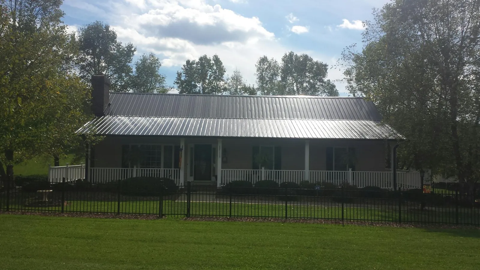 Gray metal roof on a brick ranch with a full width front porch — Gutter Guard Installation work by our crew in Yamhill